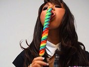 Sexy asian schoolgirl in skirt sucking on candy simulates Blowjob