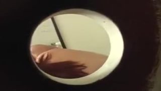 Sophie Dee giving a blowjob at the gloryhole